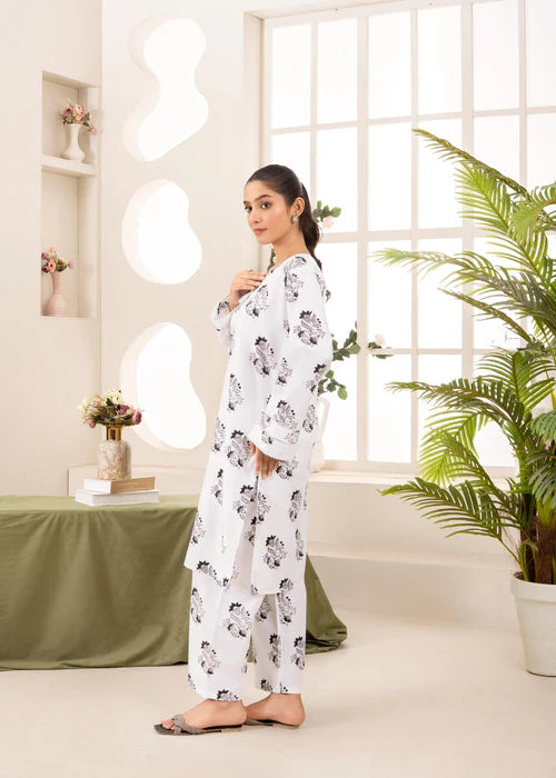 Detail of scalloped white embroidery on the hem of straight-cut trousers.