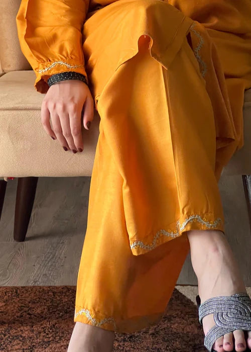 Close-up of ivory scalloped "Ringel" embroidery on a yellow Mandarin collar.