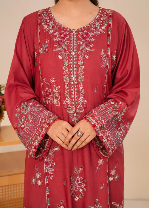 Close-up of delicate floral embroidery on a dusty rose pink shirt.