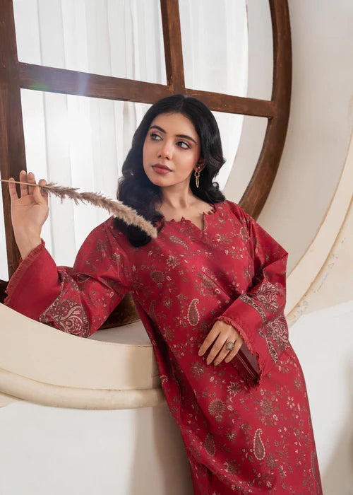 Intricate ivory wavy embroidery on the cuffs of a maroon shirt.